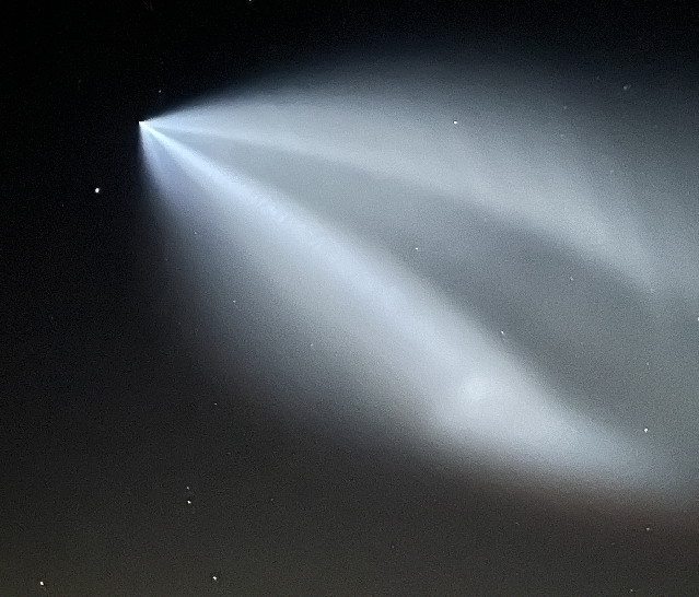 Second stage of the SpaceX launch, contrail lit up against the night sky